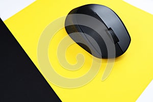 Wireless gray computer mouse on a yellow background.