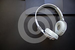 Wireless headphone resting on a laptop on a office desk