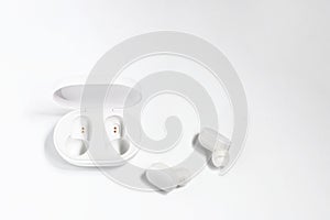 Wireless headphones and a charger to them on a white background