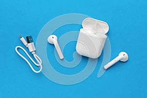 Wireless headphones with charging cable on a blue background