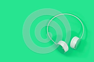 Wireless headphones isolated on light green background. bluetooth