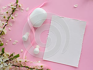 Wireless headphones on pink background with cherry flowers and copy space