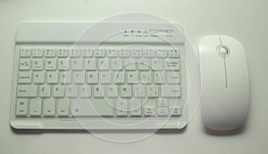 Wireless keyboard and mouse with clipping path. White keyboard with white mouse on black background. White background.  Key