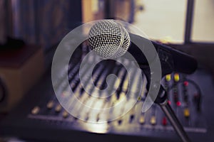 A wireless microphone on a stand in the room controls the sound