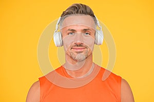 Wireless is modern. Clean sound. Modern technology. Mature man listen music wireless gadget yellow background. Hipster