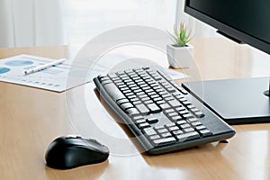Wireless mouse and keyboard set on top of a wooden office desk