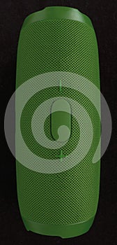 Wireless music column. Green speaker on black background.