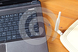 Wireless router and laptop on wooden table