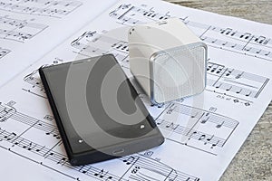 Wireless speaker and cell phone on a musical score