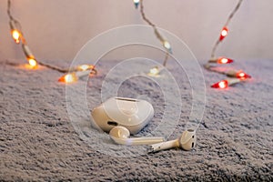 Wireless white headphones  on gray plush