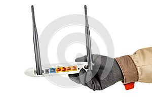 Wireless wi-fi router with colored connection ports on back panel in man hand in black protective glove and brown uniform isolated