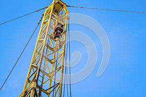 Wireline equipment hanging from top drive ready to be lowered downhole for logging. An oil well engineer works from the