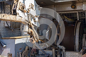 Wireline equipment hanging from top drive ready to be lowered downhole for logging. An oil well engineer works from the back of