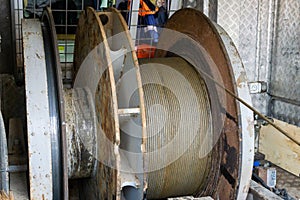 Wireline equipment hanging from top drive ready to be lowered downhole for logging. An oil well engineer works from the back of