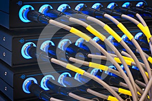 Wires connected to the network server, optical fiber. Network cables closeup with fiber optical background