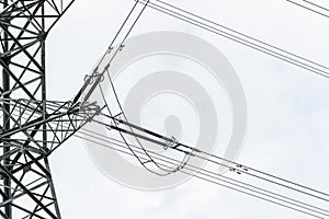 Wires diverge in different directions from the power transmission tower against the blue sky