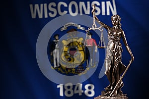 Wisconsin US state flag with statue of lady justice and judicial scales in dark room. Concept of judgement and