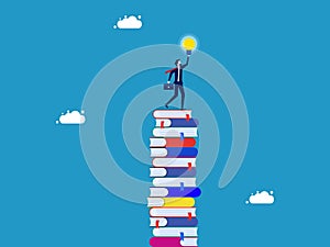 Wisdom for creative thinkers. Businessman on a high stack of books with a light bulb