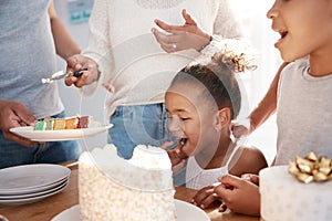 Wisdom doesnt necessarily come with age. a family preparing to eat a cake at a birthday party at home.