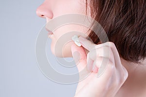 Wisdom tooth extraction, woman suffering from a toothache on gray background
