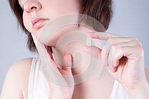 Wisdom tooth extraction, woman suffering from a toothache on gray background