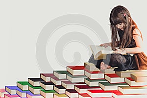 A wise little cute girl kid in a black dress sitting on pile of book reading and learning knowledge and information