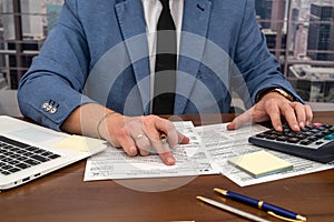 wise male businessman working with important documents at office desk.