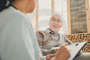 Wise old man having comfortable conversation with nurse