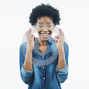 Wish, black woman and portrait with fingers crossed with hope, faith and hands. White background, studio and African