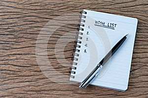 Wish list concept, pen on white paper note pad with handwritten
