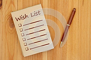 Wish list on an old paper notepad with pen