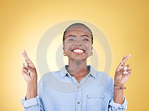 Wish sign, fingers crossed and portrait of black woman in studio smile for hope, winning and success. Emoji, excited and