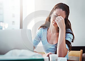 She wishes this headache could just go away. a young businesswoman trying to work while suffering with the flu.