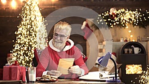 Wishlist for funny modern santa. House for Santa. Dear Santa. SantaClaus in wooden home interior reading wish list.