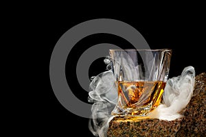 Wisky glass on the rock on black background. Wisky glass without ice