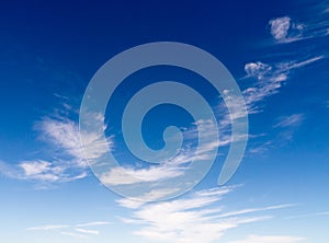 Wispy, sparce clouds in a deep blue sky photo
