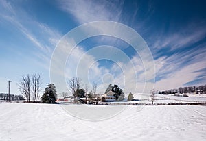 Wispy clouds over a snow covered farm in rural Carroll County, M