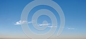 Wispy long strand clouds float across blue sky panorama