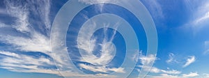 Wispy, soft clouds panorama across blue sky