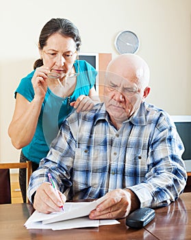 Wistful mature couple reading documents