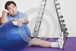 Wistful Overweight Man On Floor With Exercise Ball