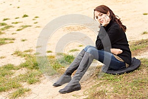 Wistful young woman sitting outdoors alone