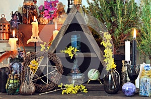 Witch altar with pentagram, spring flowers, black candles