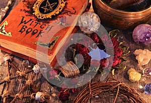 Witch book with magic rose mirror, pentagram and mystic objects on planks