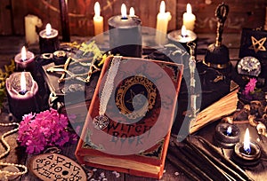 Witch books, black candles with magic and mystic objects on planks