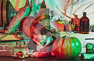 Witch children with trick or treat. Cute little witch with a pumpkin. Funny kid in carnival costumes indoors. Halloween