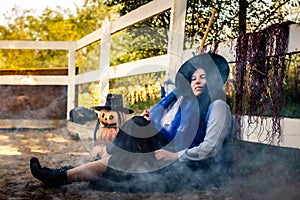 The witch at the fence sits haughtily on Halloween eve photo