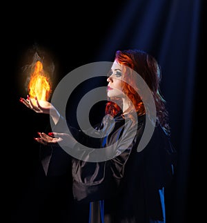 Witch with flame on blue rays background