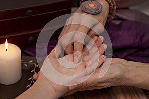 Witch fortune teller reading fortune on girls hand. The concept of magic, predictions of the future, Christmas time.