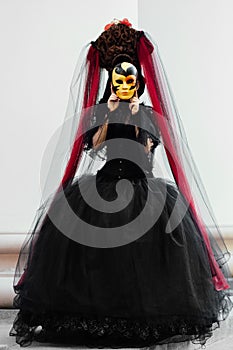 Witch portrait in black vintage dress. Woman widow with red art make-up for halloween.